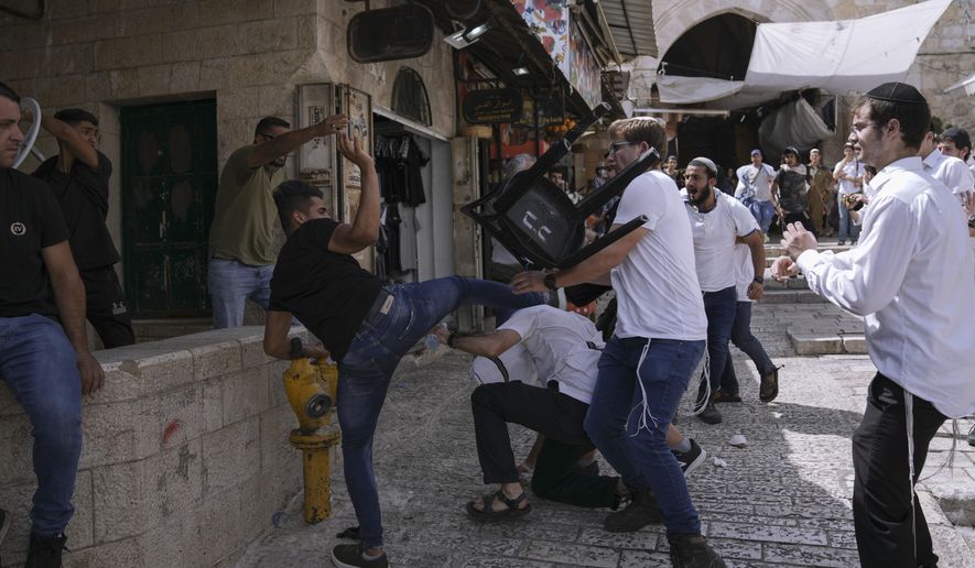 Palestinians and Jewish youths clash in Jerusalem&#39;s Old City as Israelis mark Jerusalem Day, an Israeli holiday celebrating the capture of the Old City during the 1967 Mideast war. Sunday, May 29, 2022. Israel claims all of Jerusalem as its capital. But Palestinians, who seek east Jerusalem as the capital of a future state, see the march as a provocation. Last year, the parade helped trigger an 11-day war between Israel and Gaza militants. (AP Photo/Ariel Schalit)