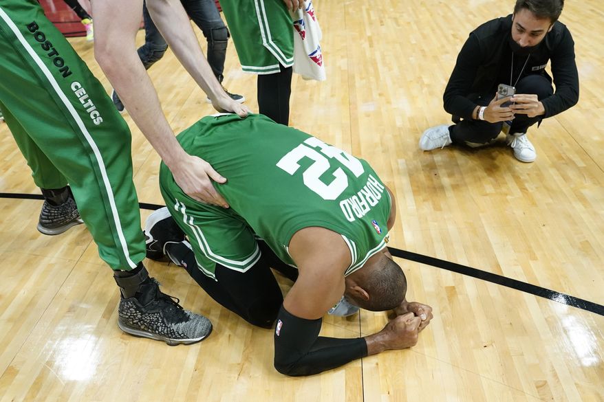 Boston Celtics center Al Horford (42) falls to his knees after winning Game 7 of the NBA basketball Eastern Conference finals playoff series against the Miami Heat, Sunday, May 29, 2022, in Miami. (AP Photo/Lynne Sladky) **FILE**