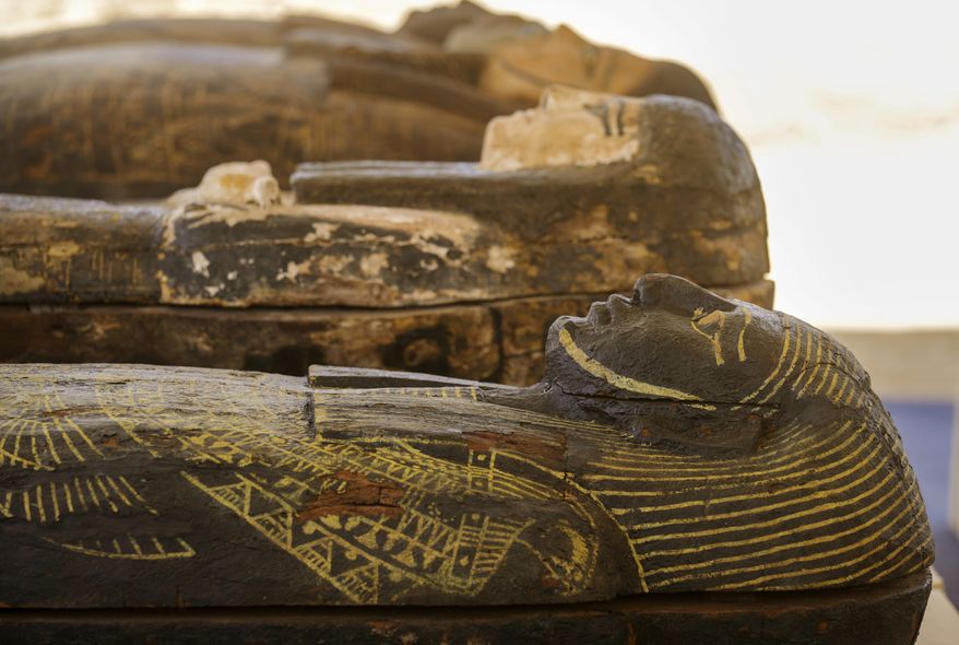 Painted coffins with well-preserved mummies inside, dating back to the Late Period of ancient Egypt around 500 B.C, are displayed at a makeshift exhibit at the feet of the Step Pyramid of Djoser in Saqqara, 24 kilometers (15 miles) southwest of Cairo, Egypt, Monday, May 30, 2022. (AP Photo/Amr Nabil)