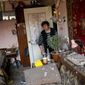 Ludmila Telehyna, 73, looks into a neighbor&#39;s appartment in the building where she lives, damaged in an overnight missile strike, in Sloviansk, Ukraine, Tuesday, May 31, 2022. (AP Photo/Francisco Seco)