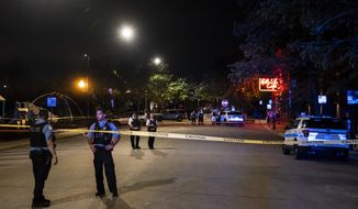 Chicago police investigate on the 500 block of West Erie Street in River North, where a 20-year-old woman was seriously injured in a shooting, Sunday night, May 29, 2022, in Chicago. (Ashlee Rezin/Chicago Sun-Times via AP)