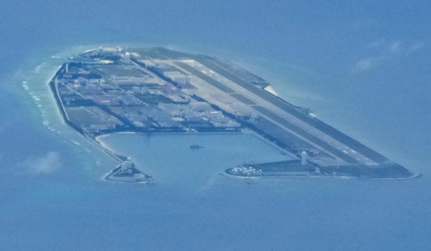 Chinese structures and buildings on the man-made Fiery Cross Reef at the disputed Spratlys group of islands in the South China Sea are seen on March 20, 2022. The Philippine government has summoned a senior Chinese diplomat in Manila to protest the harassment by the Chinese coast guard of a research vessel manned by Filipino and Taiwanese scientists in the disputed South China Sea, officials said Tuesday May 31, 2022. (AP Photo/Aaron Favila)