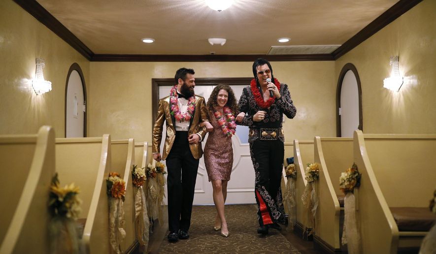 Elvis impersonator Brendan Paul, right, walks down the aisle during a wedding ceremony for Katie Salvatore, center, and Eric Wheeler at the Graceland Wedding Chapel in Las Vegas. Authentic Brands Group (ABG) sent cease-and-desist letters earlier this month to multiple chapels, saying they had to comply by the end of May, the Las Vegas Review-Journal reported. (AP Photo/John Locher, File)