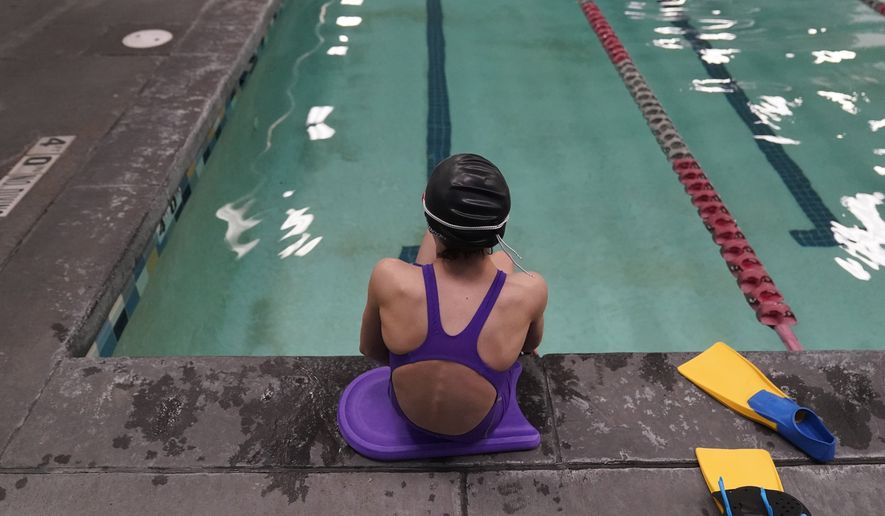 A 12 year old transgender swimmer is seen waiting by a pool on February 22, 2021 in Utah. She and her family spoke to the associated press on the condition of anonymity. Two transgender athletes and their families filed a lawsuit Tuesday, June 1, 2022, to challenge the states new ban on transgender players competing in girls sports. (AP Photo/Rick Bowmer, File)