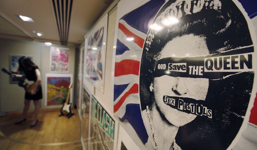 A promotional poster for the 1977 single God Save The Queen by the Sex Pistols on display, during a photo-op ahead of a rock and pop memorabilia auction, in central London, Thursday June 25, 2009. In Britain, there are several traditional elements to a royal anniversary: pageants, street parties, the Sex Pistols. Queen Elizabeth II and the Pistols have been linked since the punk pioneers released the song “God Save the Queen” in 1977 during the monarch’s Silver Jubilee. (AP Photo/Lefteris Pitarakis, File)