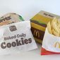 A Burger King Whopper in a wrapper, behind left, and a bag of Burger King cookies, left, rest next to a McDonald&#39;s Big Mac in a container, behind right, and a bag of McDonald&#39;s fries, in Walpole, Mass., Wednesday, April 20, 2022. Environmental and health groups are pushing dozens of fast food companies, supermarkets chains and other retail outlets to remove PFAS from their packaging. (AP Photo/Steven Senne)