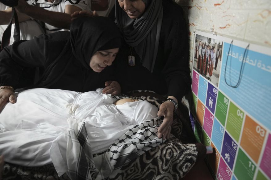 A woman mourns Ghafran Warasna, who died after she was shot in the chest near the Al Aroub refugee camp, close to the West Bank city of Hebron, Wednesday, June 1, 2022. Israeli troops shot and killed Warasna, a knife-wielding Palestinian woman, in the occupied West Bank on Wednesday, the Palestinian Health Ministry said. (AP Photo/ Mahmoud Illean)