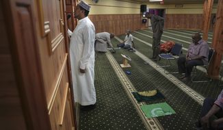 A member of the Abubakar As-Saddique Islamic Center recites the Islamic call to prayer, or adhan, on Thursday, May 12, 2022, in Minneapolis. The adhan exhorts men to go to the closest mosque five times a day for prayer, which is one of the Five Pillars of Islam. Abubakar, which hosts some 1,000 men for Friday midday prayers, plans to hold meetings with neighbors before publicly broadcasting publicly the call this summer. (AP Photo/Jessie Wardarski)