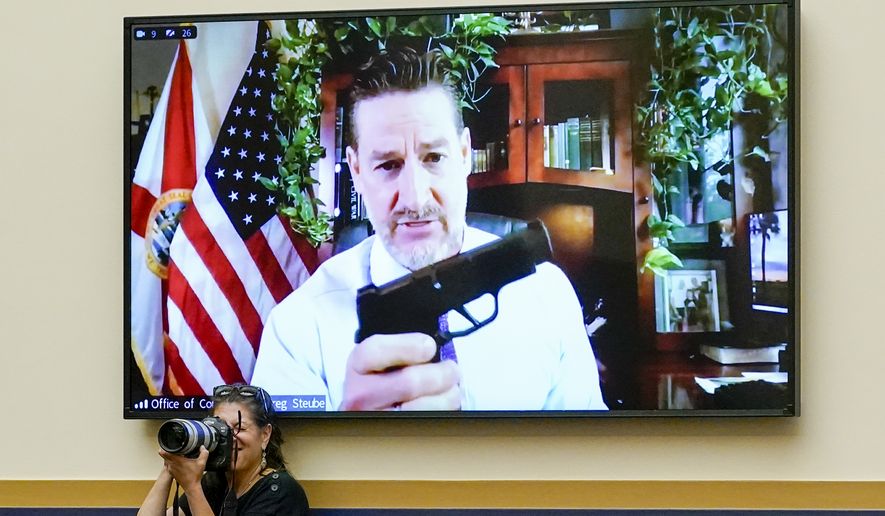 Rep. Greg Steube, R-Fla., holds up his own handgun as he speaks via videoconference as the House Judiciary Committee holds an emergency meeting to advance a series of Democratic gun control measures, called the Protecting Our Kids Act, in response to mass shootings in Texas and New York, at the Capitol in Washington, Thursday, June 2, 2022. (AP Photo/J. Scott Applewhite)