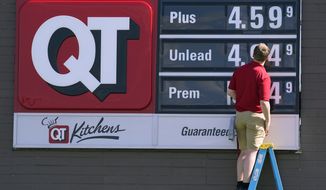 A worker changes the gasoline price sign at a QuikTrip, Thursday, June 2, 2022, in Des Moines, Iowa. (AP Photo/Charlie Neibergall)