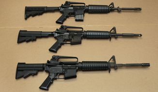 Three variations of the AR-15 assault rifle are displayed at the California Department of Justice in Sacramento, Calif., on Aug. 15, 2012. (AP Photo/Rich Pedroncelli, File)