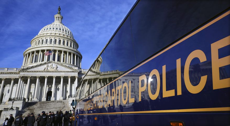 FILE - A large group of police arrive on a bus at the Capitol, Thursday, Jan. 6, 2022, in Washington. Thomas Smith, a U.S. Capitol Police officer, was indicted on federal civil rights charges after he was involved in an unauthorized high-speed chase, crashed into a motorcycle and then tried to cover it up, prosecutors said Friday, June 3. (AP Photo/Julio Cortez, File)