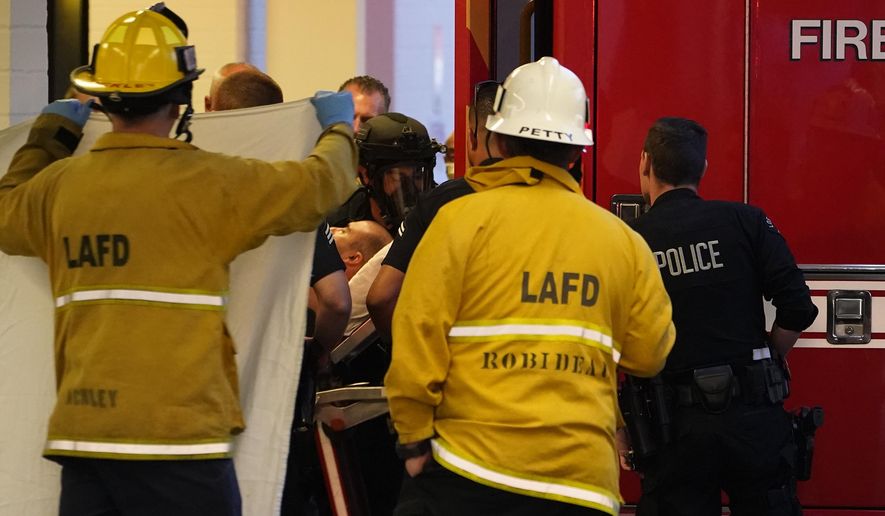 A suspect who stabbed multiple people and barricaded himself inside the Encino Hospital Medical Center is transported into a waiting ambulance after being extracted from the hospital in Encino, Calif., late Friday, June 3, 2022. (AP Photo/Damian Dovarganes)