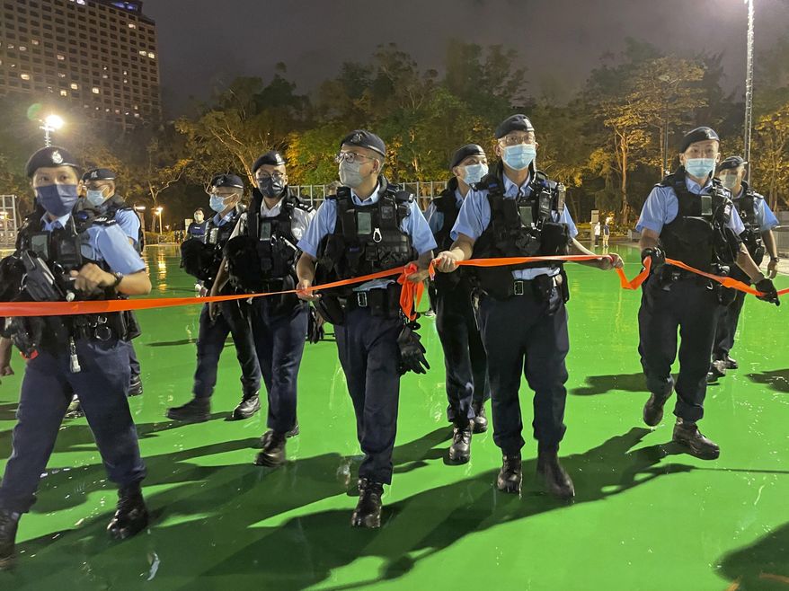 Police officers set up a cordon as Hong Kong authorities announced a temporary closure of the Victoria Park where the candlelight vigil used to be held, ahead of the 33rd anniversary to commemorate the June 4, 1989 military crackdown in Beijing's Tiananmen Square on a pro-democracy student movement, in Hong Kong, Friday, June 3, 2022. (AP Photo/Rafael Wober)