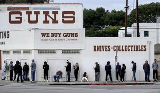 In this March 15, 2020 file photo people wait in a line to enter a gun store in Culver City, Calif. The man who shot and killed four people this week at a Tulsa, Okla., hospital bought his AR-style semiautomatic rifle just hours before he began the killing spree. That would not have been possible in Washington and a half dozen other states that have waiting periods of days or even more than a week before people can take possession of such weapons. (AP Photo/Ringo H.W. Chiu, File)