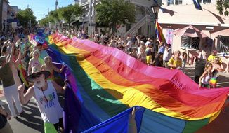 A 100-foot section of the Key West Sea to Sea Diversity flag is carried down Duval Street in Key West, Florida, on Sunday, June 5, 2022. The flag, which originally measured 1.25 miles, was created by activist Gilbert Baker and stretched the length of Duval Street from the Atlantic Ocean to the Gulf of Mexico during Key West Pridefest in 2003. (Rob O&#39;Neal/The Key West Citizen via AP)