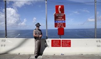 Florida Highway Patrol Sgt. Steve Gaskins stands at the peak on the southbound easement of the Sunshine Skyway Bridge on Wednesday, July 21, 2021, in St. Petersburg, Fla., where the new suicide prevention barrier has been completed. For decades, the Sunshine Skyway Bridge has been one of Tampa Bay’s most iconic landmarks. But the 190 foot-high peak has also drawn hundreds of people wanting to take their own life. (Douglas R. Clifford/Tampa Bay Times via AP) ** FILE **