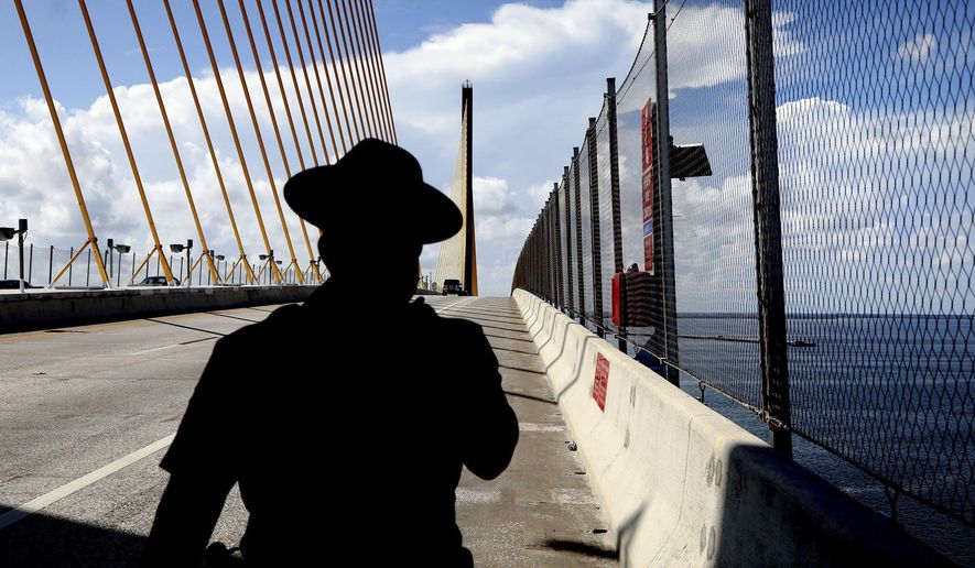 Florida Highway Patrol Sergeant Steve Gaskins walks near the peak at the southbound lanes of the Sunshine Skyway Bridge on Wednesday, July 21, 2021, in St. Petersburg, Fla. where the new suicide prevention barrier has been completed. For decades, the Sunshine Skyway Bridge has been one of Tampa Bay’s most iconic landmarks. But the 190 foot-high peak has also drawn hundreds of people wanting to take their own life. (Douglas R. Clifford/Tampa Bay Times via AP) **FILE**