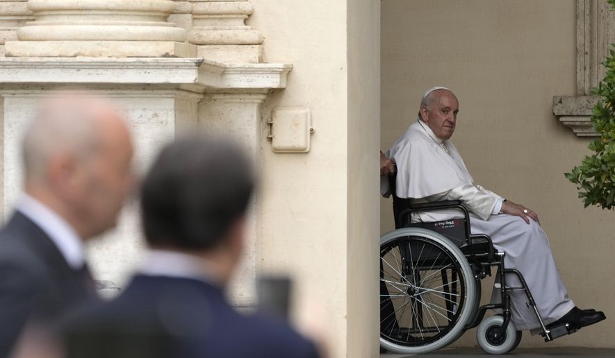 Pope Francis arrives on a wheelchair for an audience with children in the San Damaso courtyard at the Vatican, Saturday, June 4, 2022. Pope Francis added fuel to rumors about the future of his pontificate on Saturday by announcing he would visit the central Italian city of L'Aquila in August for a feast initiated by Pope Celestine V, one of the few pontiffs who resigned before Pope Benedict XVI stepped down in 2013. (AP Photo/Alessandra Tarantino, File)