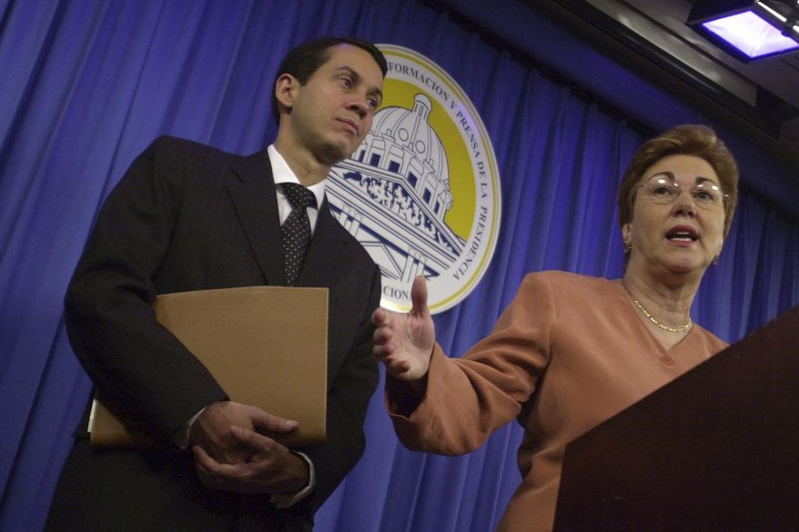 Dominican Secretary for Commerce and Industry Sonia Guzman, right, talks to the media accompanied by Orlando Jorge Mera, at the presidential palace in Santo Domingo, Dominican Republic, March 16, 2004. Mera, the Dominican Republic’s minister of the environment and natural resources, was shot and killed in his office on Monday, June 6, 2022, according to officials. (AP Photo/Walter Astrada, File)
