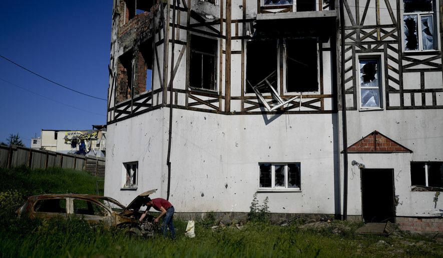 A man checks his car destroyed by attacks in Mostyshche, on the outskirts of Kyiv, Ukraine, Monday, June 6, 2022. (AP Photo/Natacha Pisarenko)