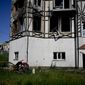 A man checks his car destroyed by attacks in Mostyshche, on the outskirts of Kyiv, Ukraine, Monday, June 6, 2022. (AP Photo/Natacha Pisarenko)