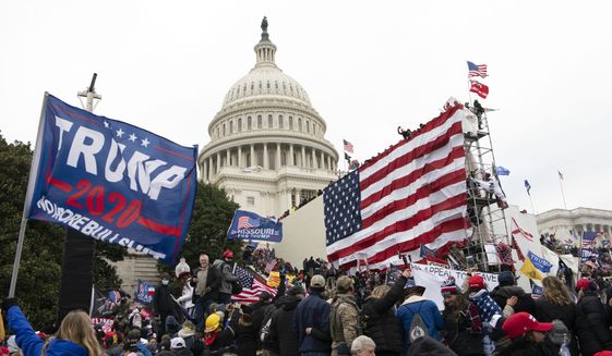 FILE - Violent insurrectionists loyal to President Donald Trump stand outside the U.S. Capitol in Washington on Jan. 6, 2021. The public hearings of the House committee investigating the insurrection pose a challenge to Democrats seeking to maintain narrow control of Congress. (AP Photo/Jose Luis Magana, File)
