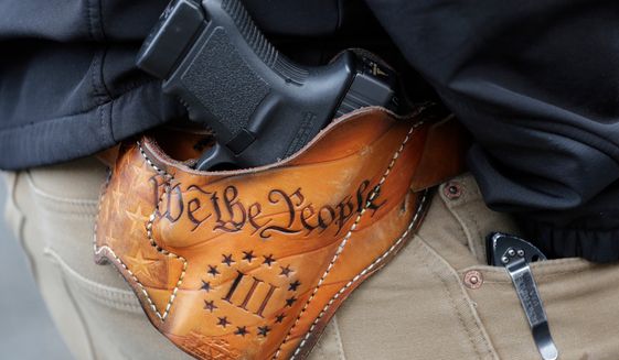 An attendee at a gun rights rally open carries his gun in a holster that reads &quot;We the People&quot; from the Preamble to the United States Constitution. (AP Photo/Ted S. Warren) **FILE**