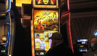 A gambler plays a slot machine at Caesars casino in Atlantic City, N.J., on Jan. 27, 2022. The casino&#39;s parent company announced, Tuesday, June 7, 2022, that Caesars will renovate its casino floor, lobby, valet area and outdoor pool this year as part of a $200 million makeover. ( AP Photo/Wayne Parry)