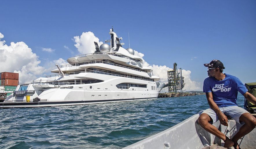 Boat captain Emosi Dawai looks at the superyacht Amadea where it is docked at the Queens Wharf in Lautoka, Fiji, on April 13, 2022. On May 5, five U.S. federal agents boarded the massive Russian-owned superyacht Amadea that was berthed in Lautoka harbor in Fiji in a case that is highlighting the thorny legal ground the U.S. is finding itself on as it tries to seize assets of Russian oligarchs around the world. (Leon Lord/Fiji Sun via AP, File)