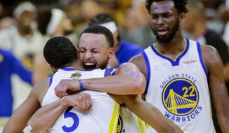 Golden State Warriors&#39; Stephen Curry, 30, hugs Jordan Poole, 3, after Poole hit a long three point shot at the end of the third quarter of Game 2 of basketball&#39;s NBA Finals against the Boston Celtics in San Francisco, on Sunday, June 5, 2022.  (Carlos Avila Gonzalez/San Francisco Chronicle via AP) **FILE**