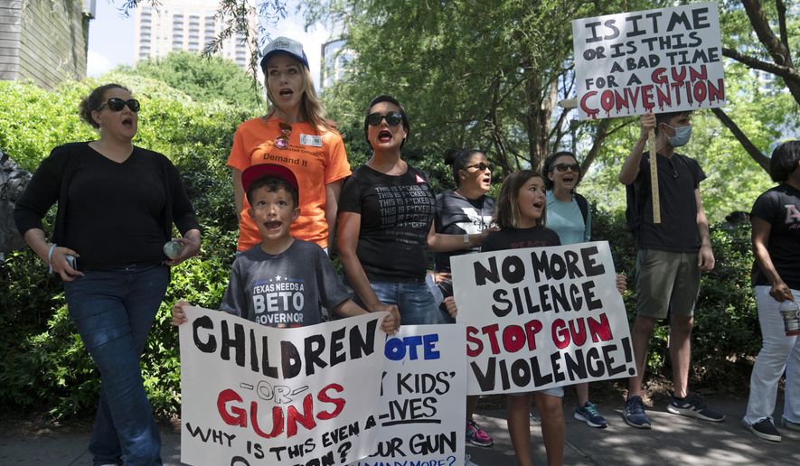 FILE - Protesters chant slogans outside the George R. Brown Convention Center to protest the National Rifle Association annual meeting in Houston, May 27, 2022. March for Our Lives and other gun control groups plan to mobilize supporters on June 11, 2022, to push Congress to require universal background checks, to pass red flag laws allowing guns to be confiscated in certain cases and to raise the age limit to purchase certain guns after recent mass shootings. (AP Photo/Jae C. Hong, File)