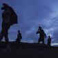 Migrants walk north on the highway toward the exit to Huixtla, Chiapas state, Mexico, at sunrise Thursday, June 9, 2022. The group left Tapachula on Monday, tired of waiting to normalize their status in a region with little work. (AP Photo/Marco Ugarte)