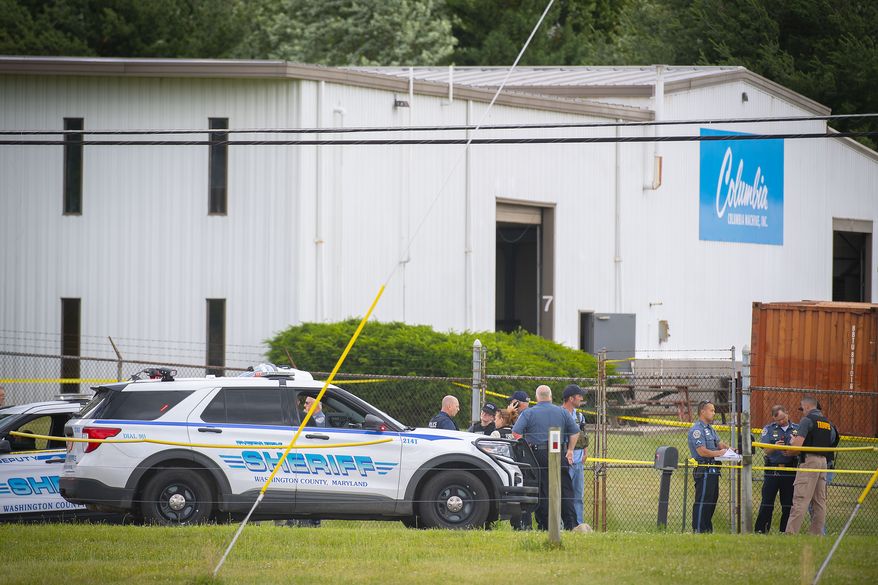 Law enforcement officials stand near the scene of a shooting at Columbia Machine, Inc., in Smithsburg, Md., Thursday, Jan. 9, 2022. (Bill Green/The Frederick News-Post via AP)