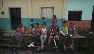 Venezuelan migrant Jesus Gonzalez, with a single crutch, sits with his family who are part of a migrant caravan that have stopped to rest in Huixtla, Chiapas state, Mexico, Wednesday, June 8, 2022. The 53-year-old man is alternating between crutches and a wheelchair pushed by relatives and friends as the family continues northward to the U.S.-Mexico border. They were the last migrants to reach Huixtla on Tuesday. (AP Photo/Marco Ugarte)
