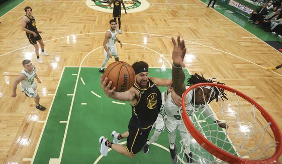 Golden State Warriors guard Klay Thompson (11) puts up a shot against Boston Celtics center Robert Williams III (44) during the second half of Game 3 of basketball&#39;s NBA Finals, Wednesday, June 8, 2022, in Boston. (Kyle Terada/Pool Photo via AP)