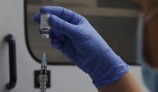 FILE - A vial of the Phase 3 Novavax coronavirus vaccine is seen ready for use in the trial at St. George&#39;s University hospital in London, Oct. 7, 2020. The Novavax COVID-19 vaccine that could soon win federal approval may offer a boost for the U.S. military: an opportunity to get shots into some of the thousands of service members who have refused the vaccine for religious reasons. (AP Photo/Alastair Grant, File)