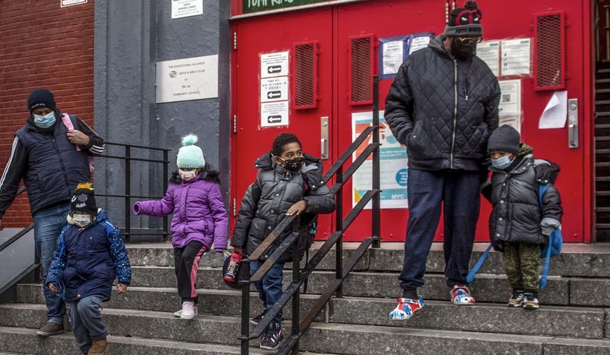 Children and their guardians wearing masks because of COVID-19 pandemic, leave P.S. 64 in the East Village neighborhood of Manhattan, Dec. 21, 2021, in New York. New York City will end its mask mandates for children under 5 on Monday, June 13, 2022, as the threat from COVID infections further subside. (AP Photo/Brittainy Newman, File) **FILE**