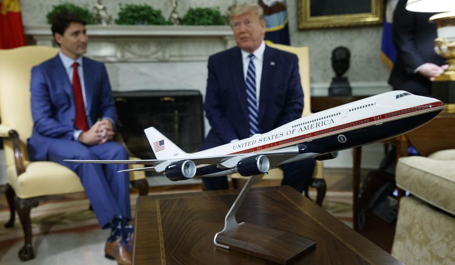 A model of the new Air Force One design sits on a table during a meeting between President Donald Trump and Canadian Prime Minister Justin Trudeau in the Oval Office of the White House, June 20, 2019, in Washington. President Joe Biden&#39;s administration has scrapped former President Trump&#39;s red, white and blue design for the new generation of presidential aircraft after an Air Force review suggested it would raise costs and delay the delivery of the new jets. (AP Photo/Evan Vucci, File)