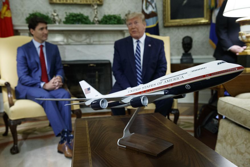 A model of the new Air Force One design sits on a table during a meeting between President Donald Trump and Canadian Prime Minister Justin Trudeau in the Oval Office of the White House, June 20, 2019, in Washington. President Joe Biden's administration has scrapped former President Trump's red, white and blue design for the new generation of presidential aircraft after an Air Force review suggested it would raise costs and delay the delivery of the new jets. (AP Photo/Evan Vucci, File)