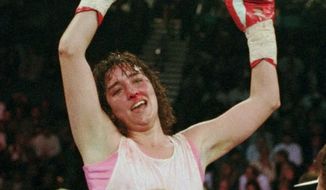 Three-time world champion Christy Martin, of Orlando, Fla., celebrates her victory over Deirdre Gogarty as her husband and trainer Jim Martin holds her up at the MGM Grand Garden in Las Vegas, March 16, 1996. Christy Martin will be inducted into the Boxing Hall of Fame in Canastota, N.Y., on Sunday, June 12, 2022. (AP Photo/Lennox McLendon, File) **FILE**