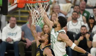 Boston Celtics forward Jayson Tatum (0) attempts to block a shot by Golden State Warriors guard Stephen Curry (30) during the first quarter of Game 4 of basketball&#39;s NBA Finals, Friday, June 10, 2022, in Boston. (AP Photo/Steven Senne)