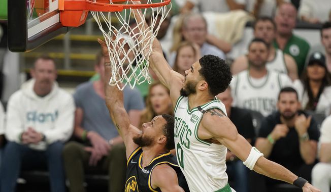 Boston Celtics forward Jayson Tatum (0) attempts to block a shot by Golden State Warriors guard Stephen Curry (30) during the first quarter of Game 4 of basketball&#x27;s NBA Finals, Friday, June 10, 2022, in Boston. (AP Photo/Steven Senne)