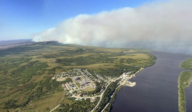 This June 10, 2022, aerial photo provided by the Bureau of Land Management Alaska Fire Service shows a tundra fire burning near the community of St. Mary&#x27;s, Alaska. The largest documented wildfire burning through tundra in southwest Alaska was within miles St. Mary&#x27;s and another nearby Alaska Native village, Pitkas Point, prompting officials Friday to urge residents to prepare for possible evacuation. (Ryan McPherson/Bureau of Land Management Alaska Fire Service via AP)