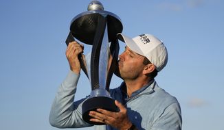 Charles Schwartzel of South Africa kisses the trophy as he poses for the media after he won the inaugural LIV Golf Invitational at the Centurion Club in St Albans, England, Saturday, June 11, 2022. (AP Photo/Alastair Grant)