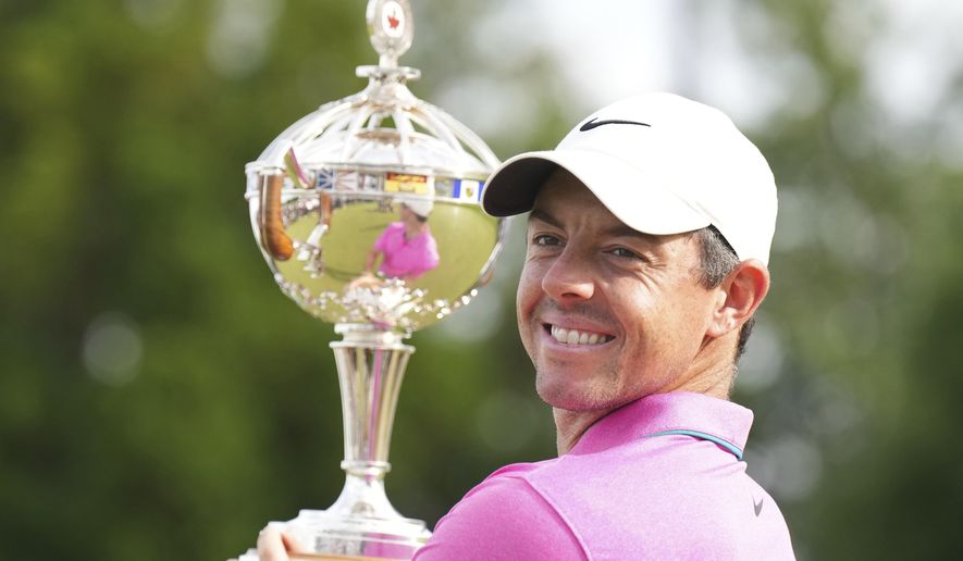 Rory McIlroy, of Northern Ireland, looks back to media as he holds the trophy after winning the final round of the Canadian Open golf tournament at St. George&#39;s Golf and Country Club in Toronto,  Sunday, June 12, 2022. (Nathan Denette/The Canadian Press via AP)