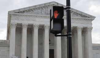 The Supreme Court and a pedestrian crosswalk sign are seen in Washington, Monday, June 13, 2022. (AP Photo/Cliff Owen)