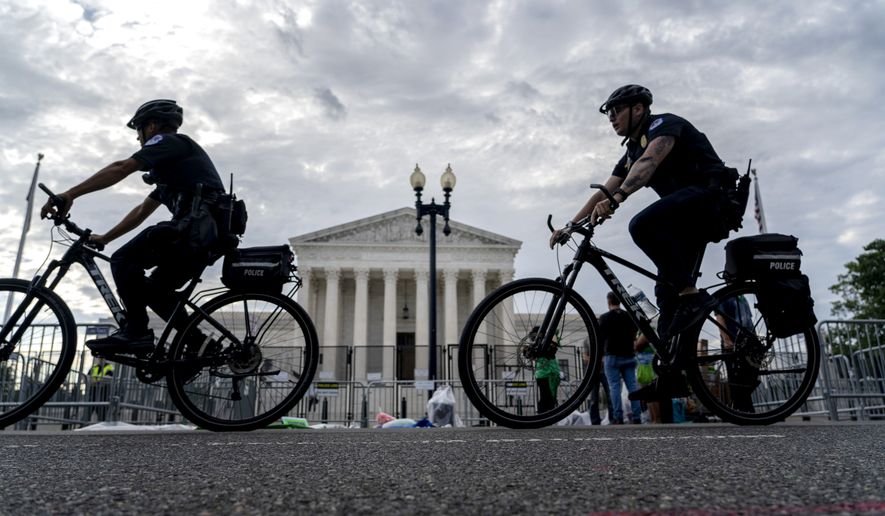 U.S Police officers patrol on bicycles past the U.S. Supreme Court building in Washington, Monday, June 13, 2022. (AP Photo/Gemunu Amarasinghe)