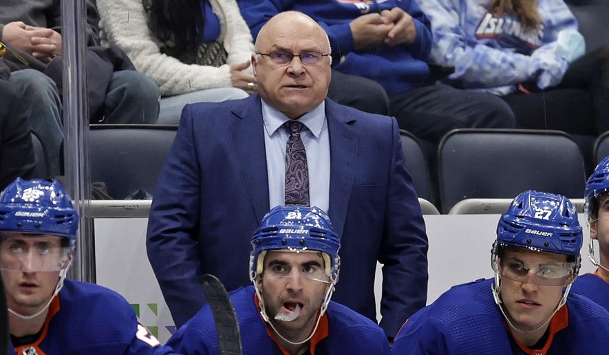 New York Islanders head coach Barry Trotz, top, looks on in the third period of an NHL hockey game against the Minnesota Wild, Jan. 30, 2022, in Elmont, N.Y. A Winnipeg brewery says it will give Trotz free beer for life if he returns to his native province to coach the Jets. (AP Photo/Adam Hunger, File) **FILE**