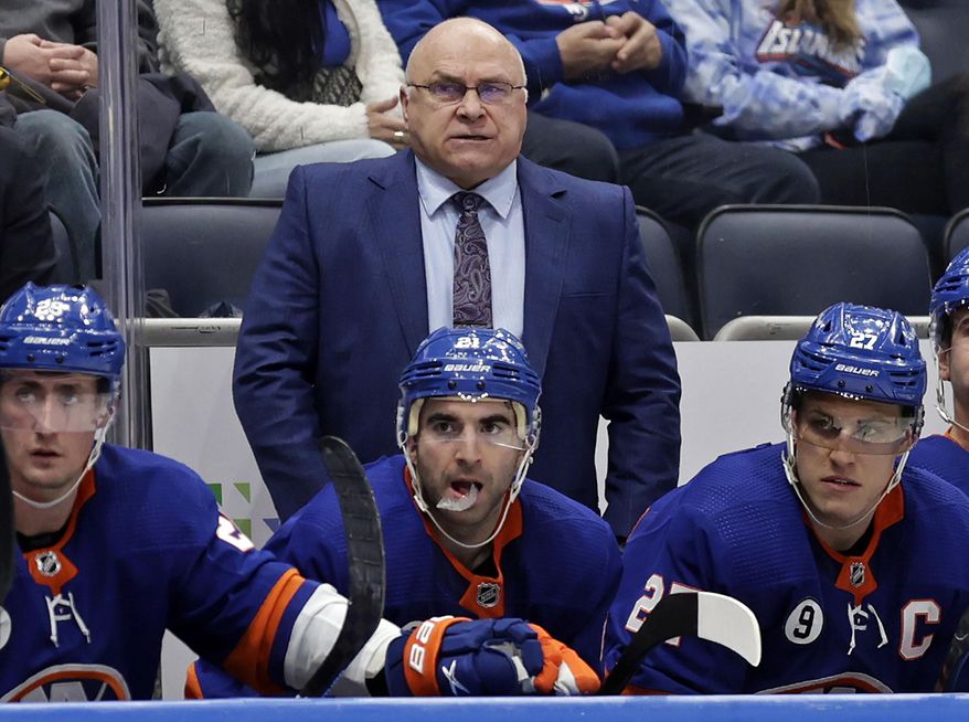 New York Islanders head coach Barry Trotz, top, looks on in the third period of an NHL hockey game against the Minnesota Wild, Jan. 30, 2022, in Elmont, N.Y. A Winnipeg brewery says it will give Trotz free beer for life if he returns to his native province to coach the Jets. (AP Photo/Adam Hunger, File) **FILE**